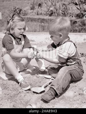 1950S FRATELLO DI RAGAZZO E SORELLA DI RAGAZZA SEDUTI INSIEME GIOCANDO IN SCATOLA DI SABBIA LITIGANDO PER NON CONDIVIDERE TOY TOOLS TUG DI GUERRA - J6484 HAR001 HARS STRUMENTI ARGOMENTARE SUBURBANO URBANO JEANS MAD SCONVOLTO VECCHIO TEMPO NOSTALGIA FRATELLO VECCHIA MODA SORELLA 1 STILE GIOVANILE RABBIA PAURA BIONDA CONCORRENZA SICUREZZA PREOCCUPAZIONE COTONE FAMIGLIE STILE DI VITA CONFLITTO INFASTIDITO FEMMINE FRATELLI MOODY HOME VITA COPIA SPAZIO A TUTTA LUNGHEZZA PERSONE MASCHI RISCHIO FRATELLI DENIM SORELLE TURBATO B&W PREOCCUPATO TRISTEZZA ESTATE ANGOSCIATO ROTTAMI IRATE ED ECCITAZIONE RICREAZIONE IN MOOD MASCHILE GEMELLA CONCETTUALE GLUM DISPIACERE AFFERRARE OSTILITÀ Foto Stock