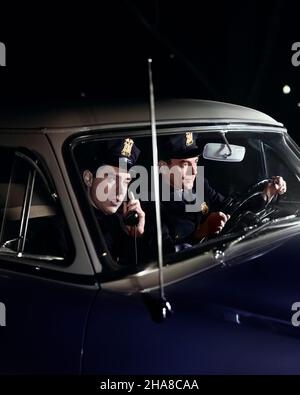 1950S COPPIA DI POLIZIOTTI IN UNIFORME PARTNERS CHE GUIDANO DI NOTTE IN PATROL PASSEGGERO UFFICIALE DI AUTO PARLARE SUL TELEFONO DELL'AUTOMOBILE - M1575C DEB001 HARS GIOVANE ADULTO SICUREZZA LAVORO DI SQUADRA MISTERO PASSEGGERO COPIA SPAZIO AMICIZIA PERSONE AUTO MASCHI RISCHIO ORDINE UFFICIALE TRASPORTO PARTNER COP PROTEGGERE TESTA E SPALLE PROTEZIONE AVVENTURA CORAGGIO E AUTOS ECCITAZIONE AUTORITÀ AUTOMOBILISMO OCCUPAZIONI UNIFORMI PATROL AUTOMOBILI VEICOLI DEB001 FUNZIONARI DI SPEDIZIONE POLIZIOTTI COMUNICAZIONI POLIZIOTTI METÀ-ADULTO UOMO PARTNER CONIUGE GIOVANE ADULTO UOMO BADGE BADGE SIGLE ETNIA CAUCASICA VECCHIO STILE Foto Stock