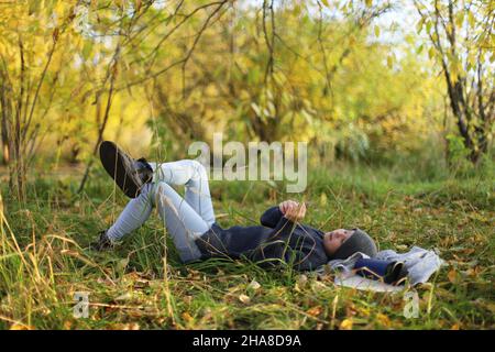 L'adolescente si trova sull'erba e si riposa nel parco Foto Stock