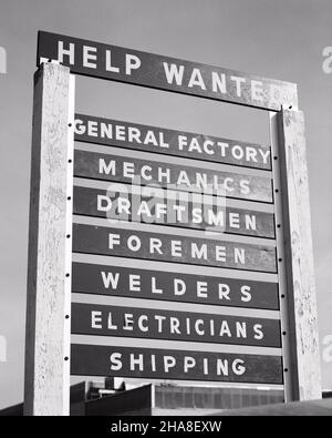 1960S HELP WANTED SIGN ON LARGE WOOD FRAME ADVERTISING FOR VARIOUS BLUE COLLAR POSITIONS WITH INDUSTRIAL BUILDING IN BACKGROUND - S15954 HAR001 HARS DIPENDENTI SALDATORI DRAFTSMEN HELP WANTED POSITIONS SHIPPING WANTED NERO E BIANCO HAR001 LAVORO VECCHIO STILE Foto Stock