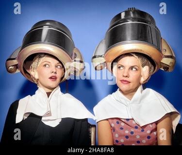 1950S DUE DONNE SEDUTE SOTTO SALONE DI BELLEZZA ASCIUGACAPELLI INDOSSANDO PELO RETE ASCIUGAMANI COMUNICANTE GOSSIPING - S8918C DEB001 SIGNORE HARS PERSONE FRATELLI SORELLE GOSSIPING ESPRESSIONI GIRLFRIEND ASCIUGAMANI TESTA E SPALLE SCOPERTA ESSICCAZIONE NETWORKING ECCITAMENTO HAIRSTYLE CONOSCENZA INCREDULITÀ FEMMINILE CASALINGHE FRATELLO GOSSIPS ASCIUGATRICI GIRLFRIENDS DEB001 SOSPETTO PELO RETI METÀ-ADULTO METÀ-ADULTO DONNA SCETTICO UNIONE GIOVANE ADULTA DONNA CAUCASICA ETNIA VECCHIO STILE DUE DONNE Foto Stock