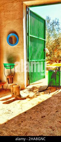 Magazzino rurale con attrezzi agricoli con porta in metallo. Foto Stock