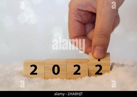 Donna a mano flipping 2021 a Capodanno 2022 su cubi di legno Foto Stock