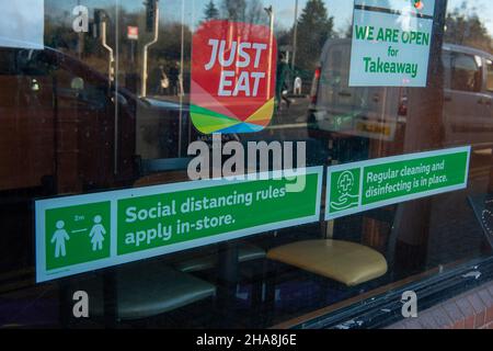 Gerrards Cross, Buckinghamshire, Regno Unito. 10th dicembre 2021. Il Covid-19 misura gli avvisi nella finestra di un take away. Credit: Maureen McLean/Alamy Foto Stock