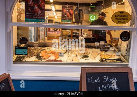 Il banco del pesce deli nella vetrina del negozio Evans Fishmonger and Butcher di Alresford, Hampshire, Inghilterra, Regno Unito Foto Stock