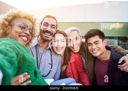 Giovani diversi festeggiano ridere insieme prendendo selfie all'aperto. Multiculturale amici felici divertirsi. Giovani diversi festeggiamenti Foto Stock