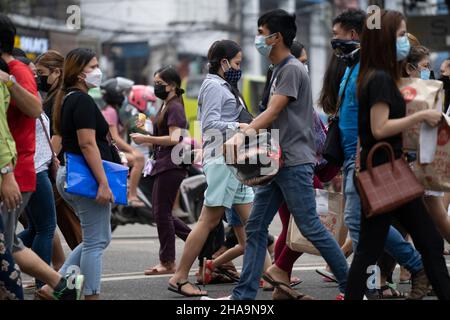 La gente nelle Filippine che attraversa una strada che indossa maschere facciali, l'uso di maschere facciali nei luoghi pubblici e negli stabilimenti è obbligatorio. Foto Stock
