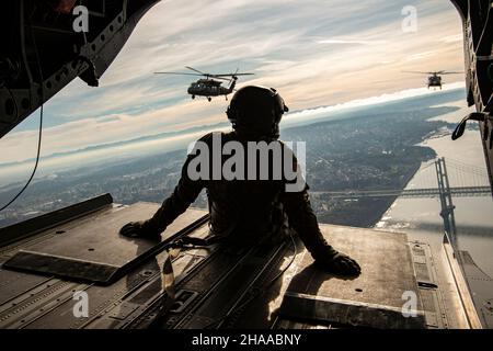 I soldati dell'esercito degli Stati Uniti, assegnati al 96esimo comando della truppa dell'aviazione, la Guardia Nazionale dell'esercito di Washington, viaggiano a Lumen Field per un volo multi-nave delle cerimonie di premame, vicino Seattle, Washington, 21 novembre 2021. La multi-nave, composta da un CH-47 Chinook e due elicotteri UH-60 Black Hawk, è arrivata poco prima della partita di football dei Seattle Seahawks contro gli Arizona Cardinals. (STATI UNITI Guardia Nazionale dell'esercito foto di Sgt. Adeline Witherspoon) Foto Stock