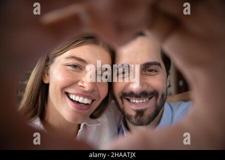 Felice eccitato coppia ritratto sposato con mano a forma di cuore cornice Foto Stock