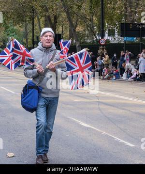 Un uomo cammina lungo Victoria Embankment vendendo bandiere britanniche prima dello spettacolo del Signore Sindaco, 2021. Foto Stock