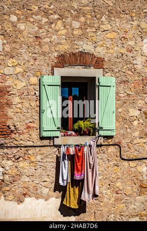 Vestiti che asciugano al sole su un balcone casa a Cessenon sur Orb, Francia Foto Stock