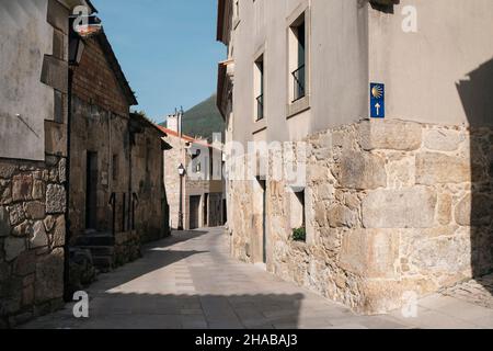 Segni della via di Santiago sul muro. Una strada di Oia, Galizia, Spagna. Foto Stock