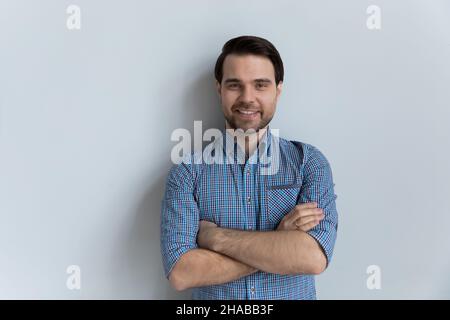 Il ragazzo in maglia blu casual posa su sfondo grigio studio Foto Stock