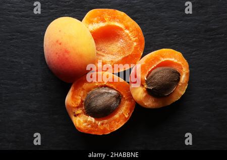 Fotografia di albicocche aperte e tagliate a metà e di noccioli di albicocche per sfondo alimentare Foto Stock