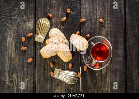 Biscotti di farina d'avena con noci e un bicchiere di tè su sfondo di legno - vista dall'alto Foto Stock