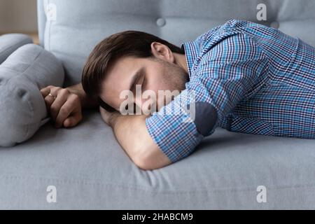 Ragazzo esausto sdraiato sul divano Foto Stock