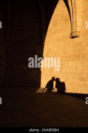 ombra di coppia baciante sulle mura luminose della città Foto Stock