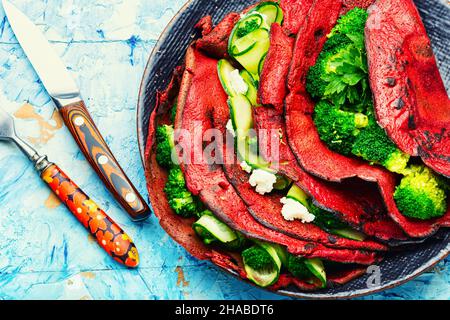 Piatto di frittelle di barbabietole farcite di verdure. Nutrizione adeguata. Foto Stock