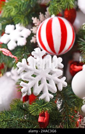 Ornamento bianco fiocco di neve su albero di Natale decorato Foto Stock