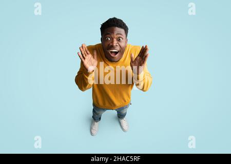 Vista dall'alto di un ragazzo afro-americano sorpreso che guarda la macchina fotografica Foto Stock