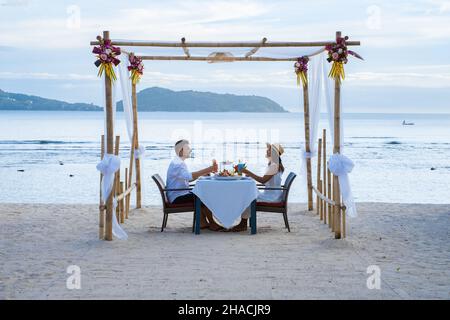 Cena romantica sulla spiaggia di Phuket Thailandia, coppia uomo e donna di mezza età Asian donna e uomo europeo a cena sulla spiaggia in Thailandia durante il tramonto. Foto Stock