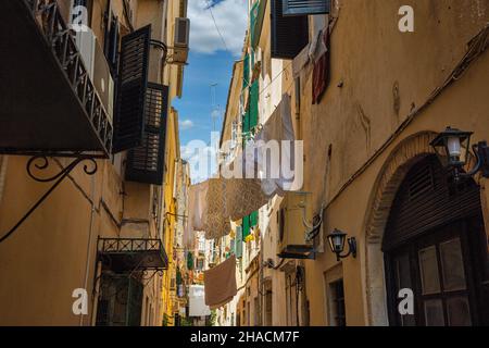 La lavanderia lavata è asciugata sul clothesline in strette strade di Kerkyra, isola di Corfù, Grecia. Foto Stock