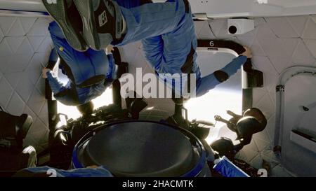 A BORDO DEL NUOVO SHEPARD, TERRA - 13 Ottobre 2021 - due astronauti di origine Blu (tra cui William Shatner) guardano fuori nello spazio mentre si trova in un sub-orbitale Foto Stock