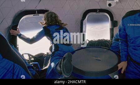 A BORDO DEL NUOVO SHEPARD, TERRA - 13 Ottobre 2021 - due astronauti di origine Blu (tra cui William Shatner) guardano fuori nello spazio mentre si trova in un sub-orbitale Foto Stock