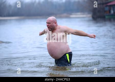 Refrigerato all'uomo bodypositive osso che si tuffa in acqua ghiacciata dopo aver battezzato durante la festa Epifania sul fiume Dnipro. Gennaio 19, 2020. Kiev, Regno Unito Foto Stock