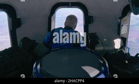 A BORDO DEL NUOVO SHEPARD, TERRA - 13 Ottobre 2021 - gli astronauti di origine Blu (incluso William Shatner, centro) guardano fuori nello spazio mentre in un fl sub-orbitale Foto Stock