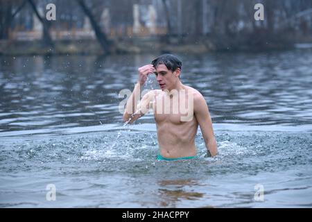 Refrigerato all'uomo d'osso che si tuffa in acqua ghiacciata dopo aver battezzato durante la festa Epifania sul fiume Dnipro. Gennaio 19, 2020. Kiev, Ucraina Foto Stock