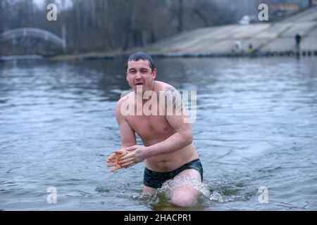 Refrigerato all'uomo d'osso che si tuffa in acqua ghiacciata dopo aver battezzato durante la festa Epifania sul fiume Dnipro. Gennaio 19, 2020. Kiev, Ucraina Foto Stock