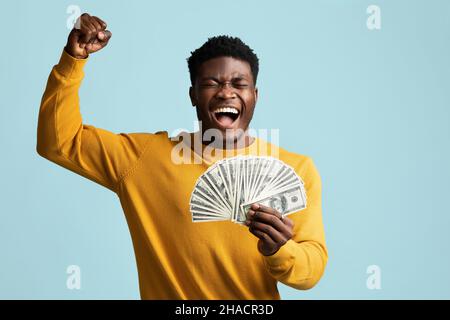 Uomo nero emotivo con mazzo di cassa aumento mano in su Foto Stock