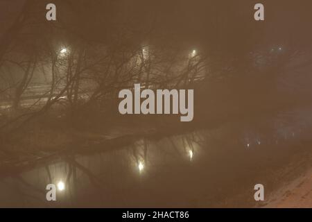 Nebbia in città in serata illuminata da lampioni. Notte. Foto Stock