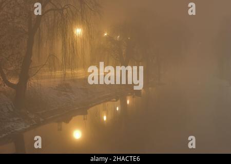 Nebbia in città in serata illuminata da lampioni. Notte. Foto Stock