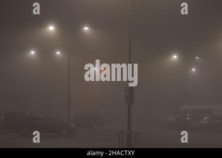 Nebbia in città in serata illuminata da lampioni. Notte. Foto Stock