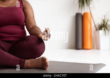 Donna afroamericana sportiva irriconoscibile in meditating sportivo Foto Stock