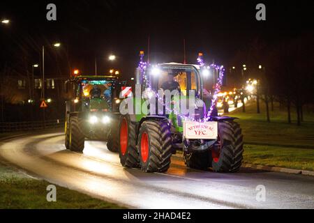 La terza sfilata annuale di trattori decorati a Natale. Oltre 70 trattori coperti da luci festive hanno fatto il loro modo attraverso i villaggi del Warwickshire per due sere. L'evento è organizzato dalla Sheepy aring Association. I coltivatori hanno sollevato oltre ventimila libbre. Foto Stock