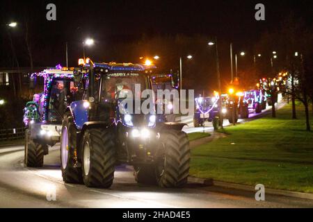 La terza sfilata annuale di trattori decorati a Natale. Oltre 70 trattori coperti da luci festive hanno fatto il loro modo attraverso i villaggi del Warwickshire per due sere. L'evento è organizzato dalla Sheepy aring Association. I coltivatori hanno sollevato oltre ventimila libbre. Foto Stock