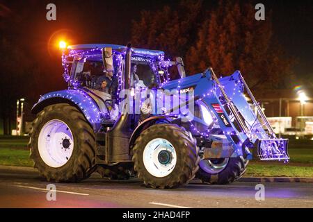 La terza sfilata annuale di trattori decorati a Natale. Oltre 70 trattori coperti da luci festive hanno fatto il loro modo attraverso i villaggi del Warwickshire per due sere. L'evento è organizzato dalla Sheepy aring Association. I coltivatori hanno sollevato oltre ventimila libbre. Foto Stock