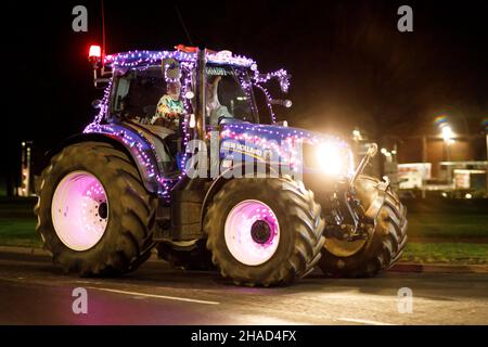 La terza sfilata annuale di trattori decorati a Natale. Oltre 70 trattori coperti da luci festive hanno fatto il loro modo attraverso i villaggi del Warwickshire per due sere. L'evento è organizzato dalla Sheepy aring Association. I coltivatori hanno sollevato oltre ventimila libbre. Foto Stock