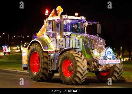 La terza sfilata annuale di trattori decorati a Natale. Oltre 70 trattori coperti da luci festive hanno fatto il loro modo attraverso i villaggi del Warwickshire per due sere. L'evento è organizzato dalla Sheepy aring Association. I coltivatori hanno sollevato oltre ventimila libbre. Foto Stock