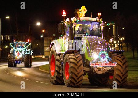 La terza sfilata annuale di trattori decorati a Natale. Oltre 70 trattori coperti da luci festive hanno fatto il loro modo attraverso i villaggi del Warwickshire per due sere. L'evento è organizzato dalla Sheepy aring Association. I coltivatori hanno sollevato oltre ventimila libbre. Foto Stock