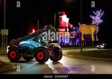 La terza sfilata annuale di trattori decorati a Natale. Oltre 70 trattori coperti da luci festive hanno fatto il loro modo attraverso i villaggi del Warwickshire per due sere. L'evento è organizzato dalla Sheepy aring Association. I coltivatori hanno sollevato oltre ventimila libbre. Foto Stock