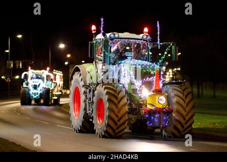 La terza sfilata annuale di trattori decorati a Natale. Oltre 70 trattori coperti da luci festive hanno fatto il loro modo attraverso i villaggi del Warwickshire per due sere. L'evento è organizzato dalla Sheepy aring Association. I coltivatori hanno sollevato oltre ventimila libbre. Foto Stock