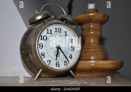 Vecchio orologio con sveglia a spirale e candeliere in legno Foto Stock