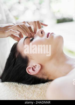 Una donna riceve un facciale purificante, un viso profondo 50 minuti che utilizza essenze di fiori, argille attive, e piante estratti di lavanda, limone Foto Stock