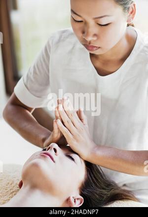 Una donna riceve un facciale purificante, un viso profondo 50 minuti che utilizza essenze di fiori, argille attive, e piante estratti di lavanda, limone Foto Stock