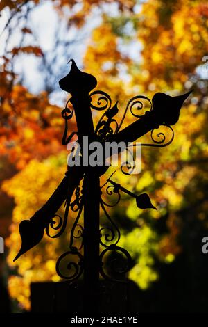 Vecchia silhouette a croce in metallo rotta sullo sfondo autunnale. Foto Stock