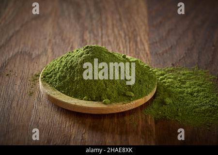 Polvere di Moringa in ciotola di legno con fondo in legno Foto Stock